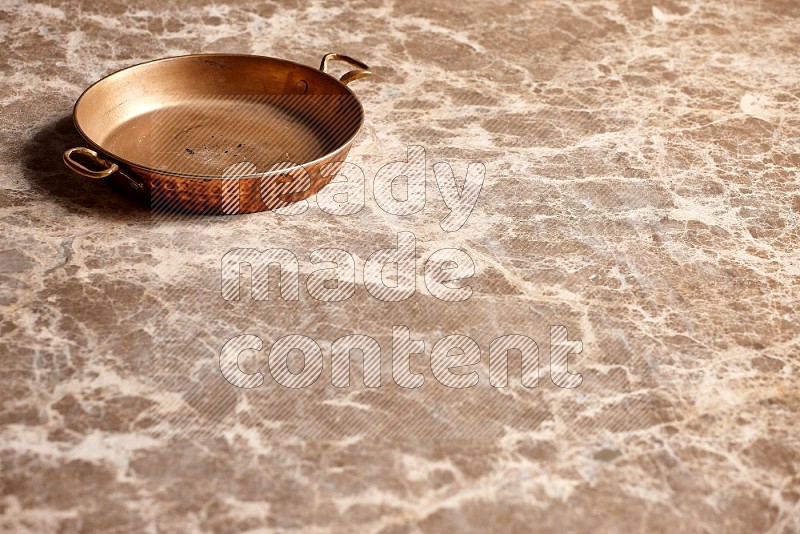 Small Copper Pan on Beige Marble Flooring, 45 degrees