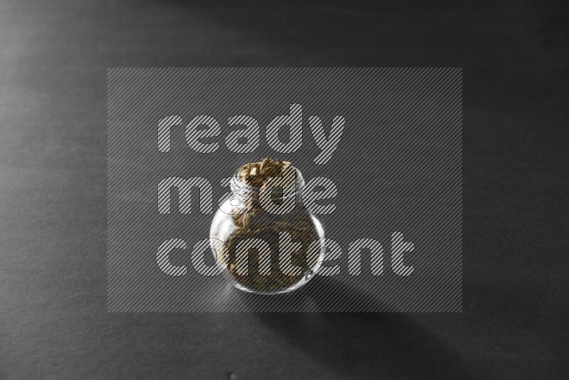 هيل في وعاء زجاجي علي خلفية سوداء