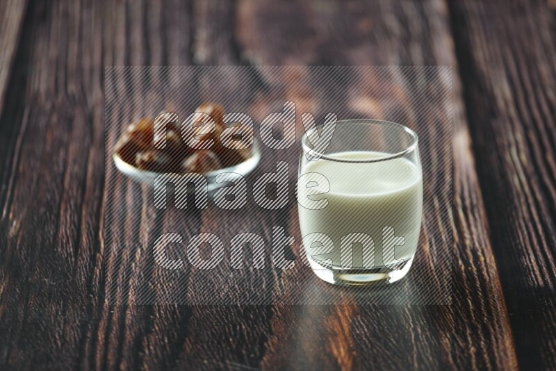 Cold drinks in a glass cup with dates such as water, tamarind, qamar eldin, sobia, milk and hibiscus on wooden background