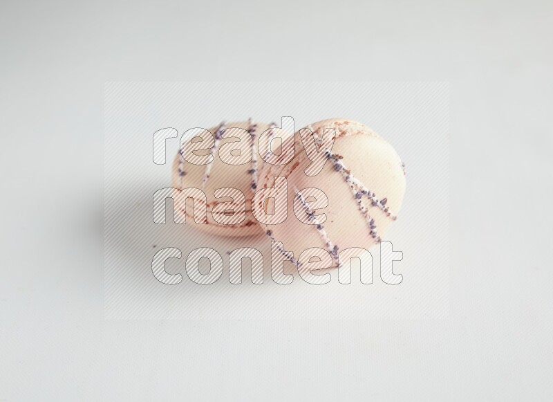45º Shot of two pink orange blossom macarons on white background