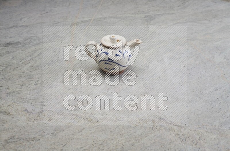 A pottery teapot on grey marble background