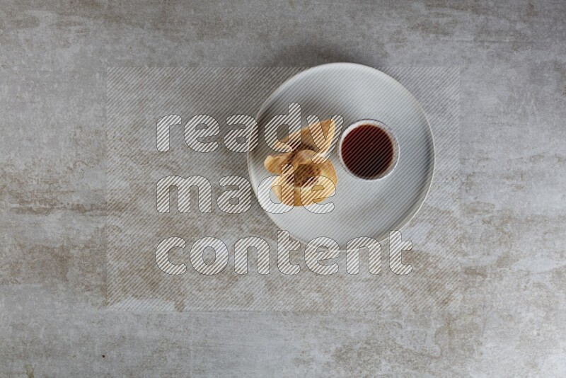 wonton cups with soy sauce ramkin on grey ceramic plate on grey textured counter top