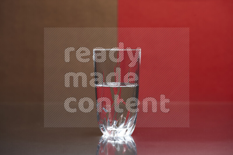 The image features a clear glassware filled with water, set against brown and red background