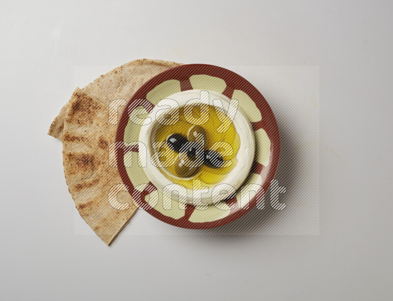 Lebnah garnished with olives in a traditional plate on a white background