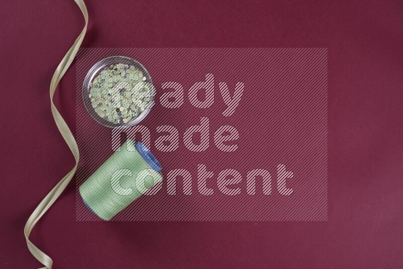 مجموعة من أدوات الخياطة والتفصيل خضراء وحمراء اللون على خلفية حمراء