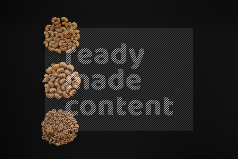 Different pasta types in 3 bunches on black background