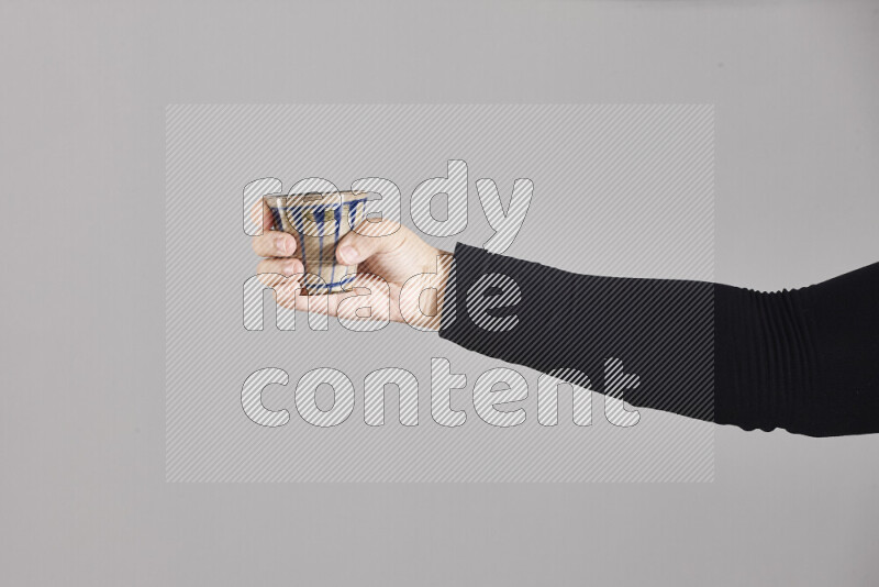 امرأة ترتدي عباءة سوداء تحمل أدوات فخارية مختلفة في أوضاع متعددة