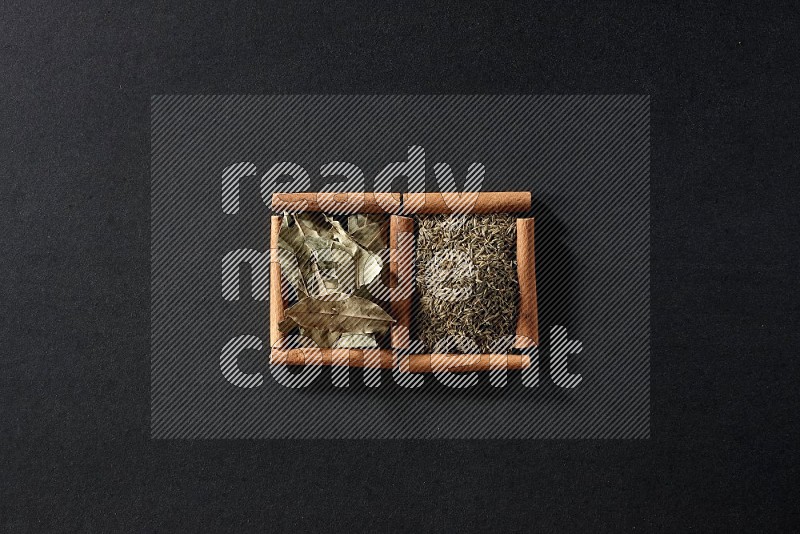 2 squares of cinnamon sticks full of cumin and bay laurel leaves on black flooring