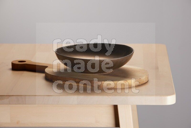 brass plate placed on a  wooden oval cutting board on the edge of wooden table