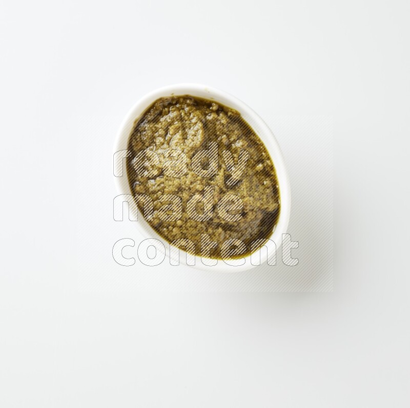 medium white ceramic oval bowl filled with pesto paste on a white counter top