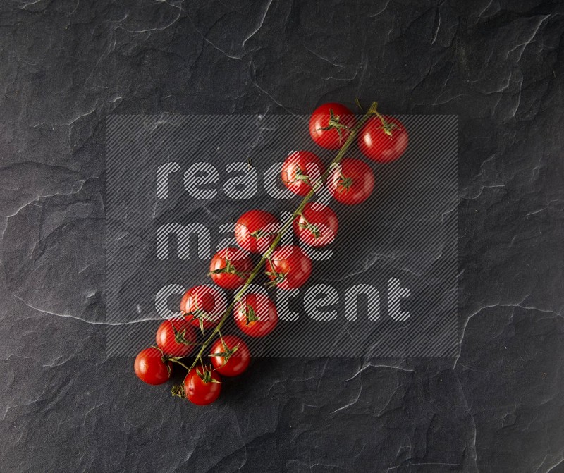 single cherry tomato vein topview on a black slate background