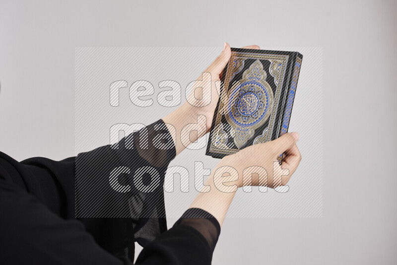 A woman hands holding moshaf in different positions