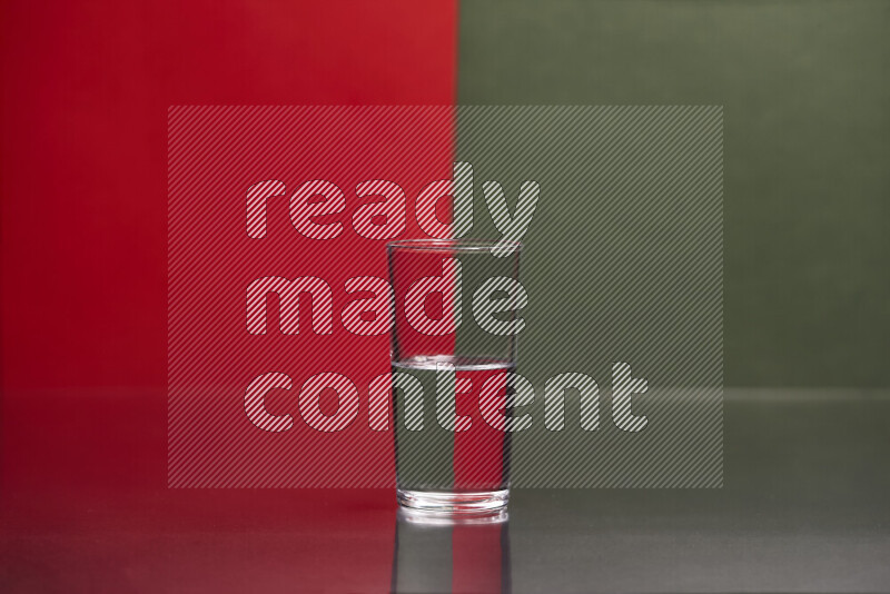 The image features a clear glassware filled with water, set against red and dark green background