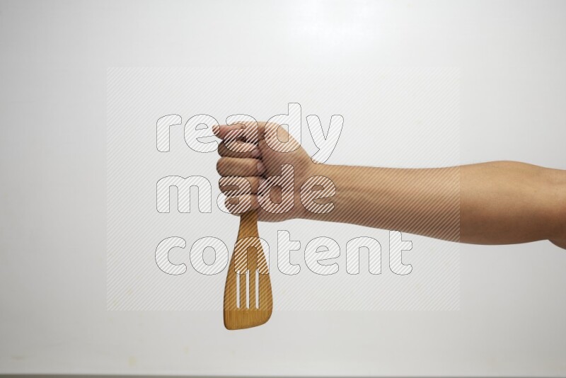 Male Hand Holding Slotted Turner on white background