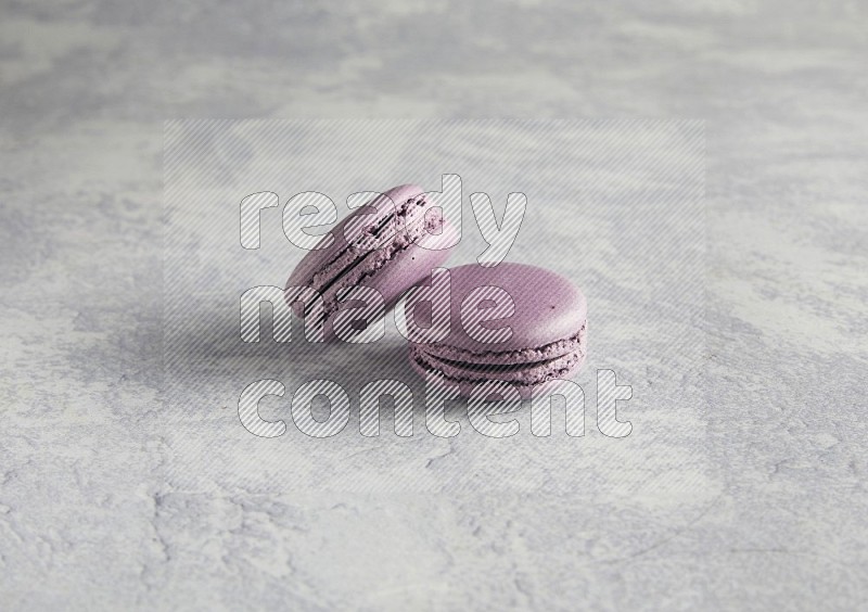 45º Shot of two Purple Blueberry macarons  on white  marble background