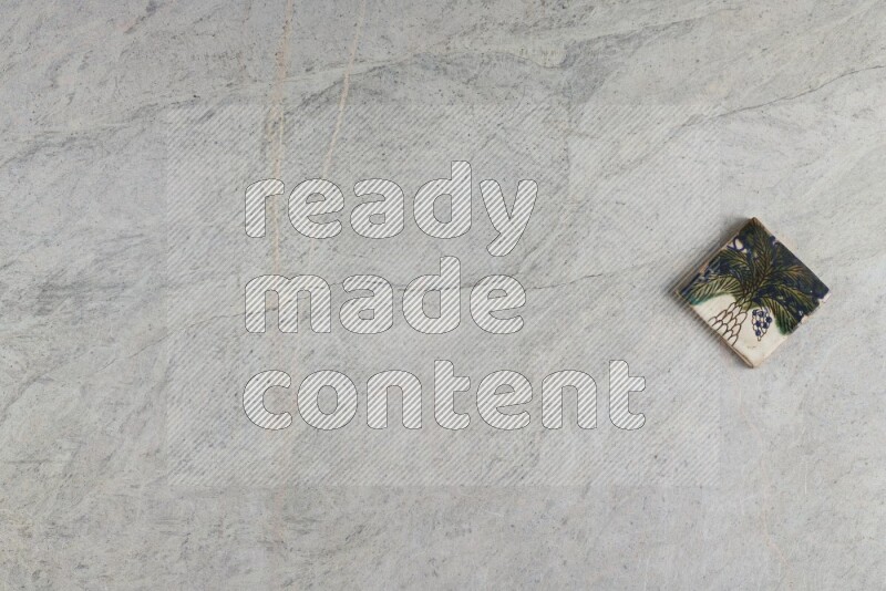 A decorative pottery coaster on grey marble background