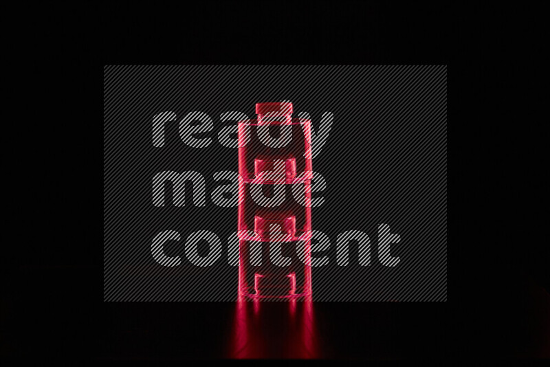 Glassware with rim light in red against black background