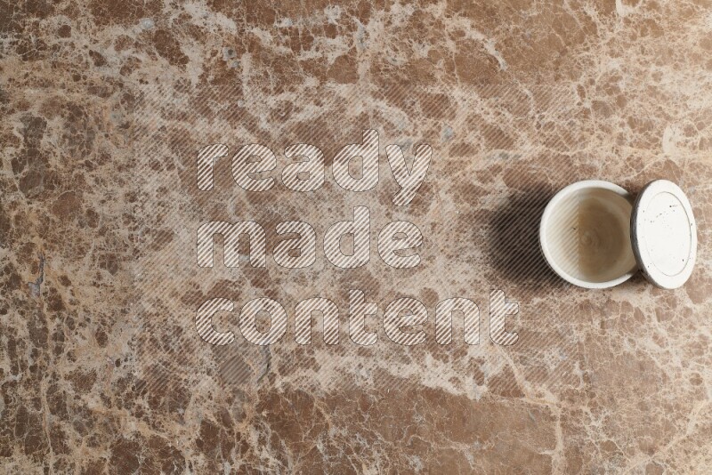 A pottery cup on beige marble background