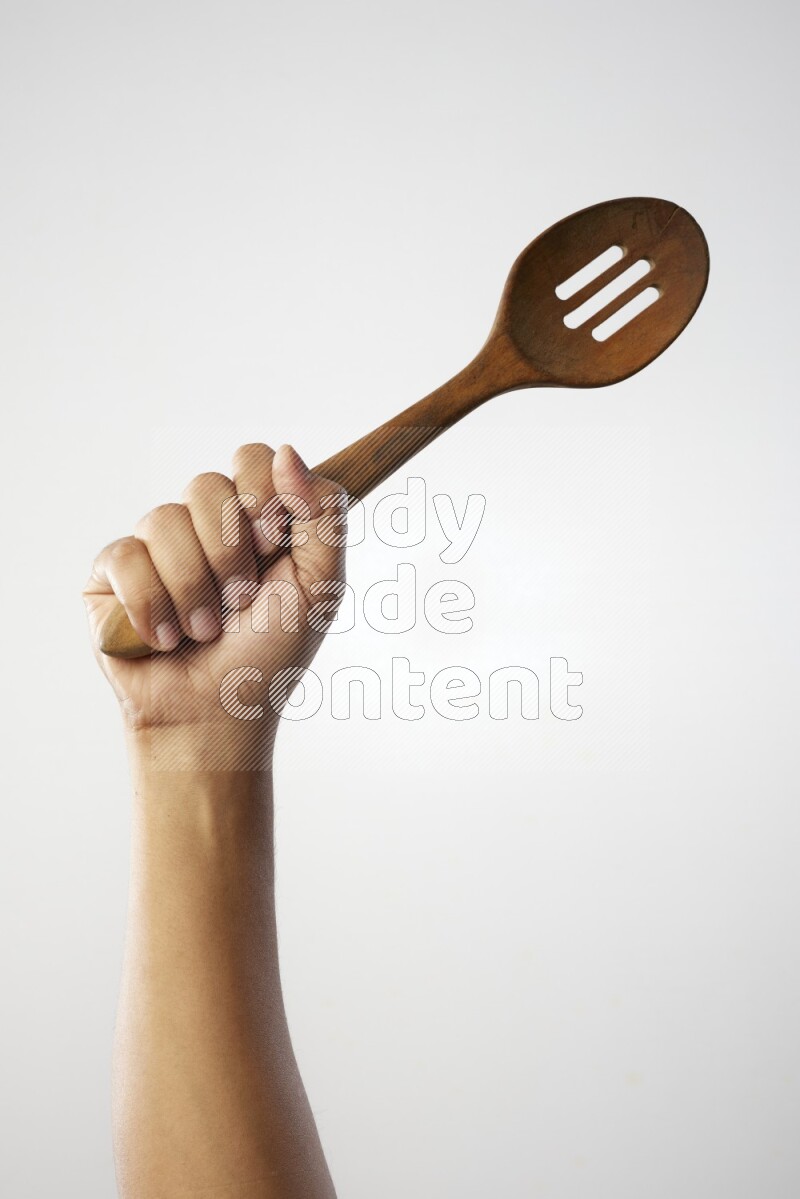 Male Hand Holding Wooden colander spoon  on white background