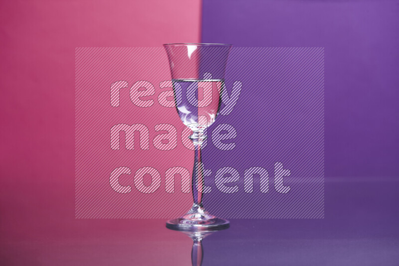 The image features a clear glassware filled with water set against pink and purple background
