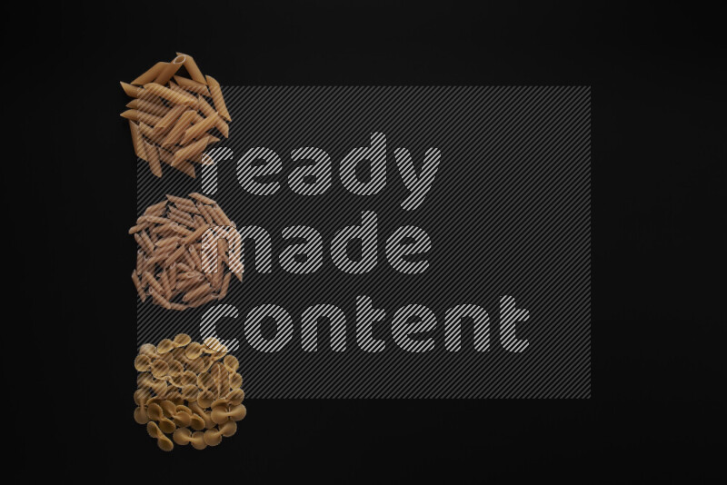 Different pasta types in 3 bunches on black background