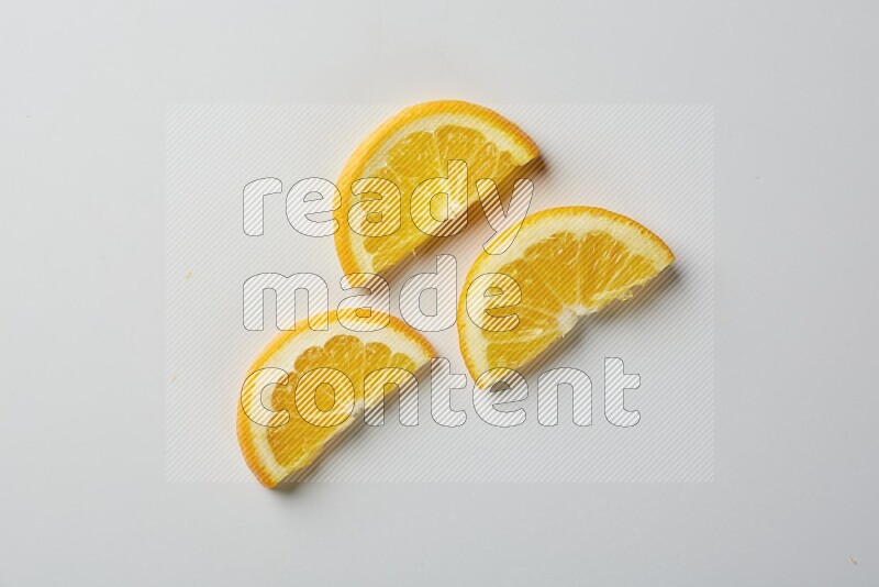 Three halves of an orange slices on white background