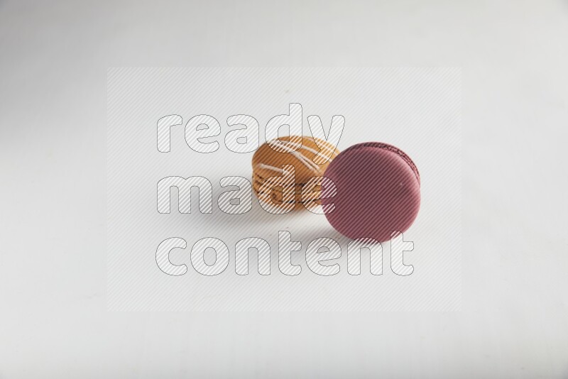 45º Shot of of two assorted Brown Irish Cream, and Red Cherry macarons on white background