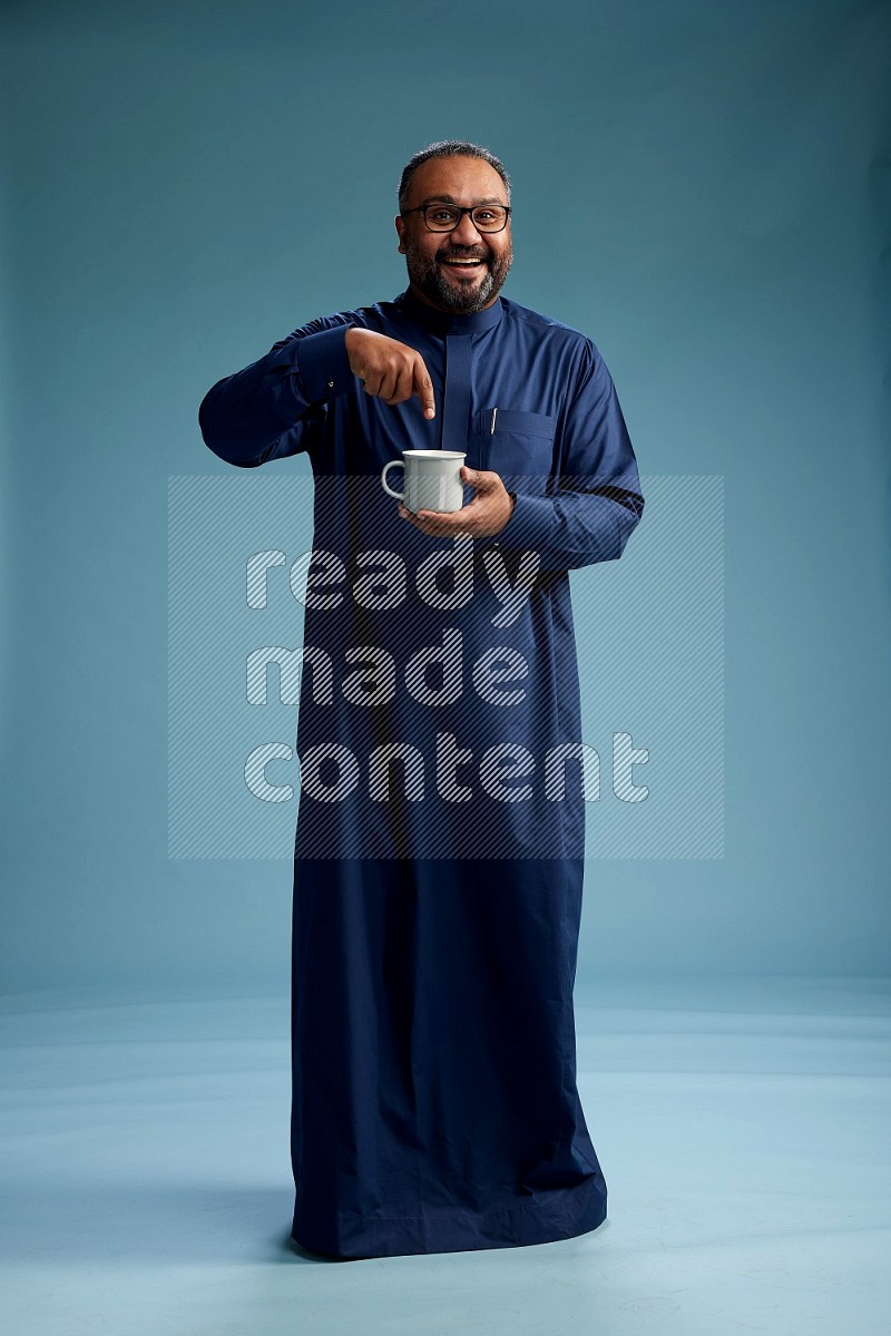 Saudi Man without shimag Standing drinking coffee on blue background