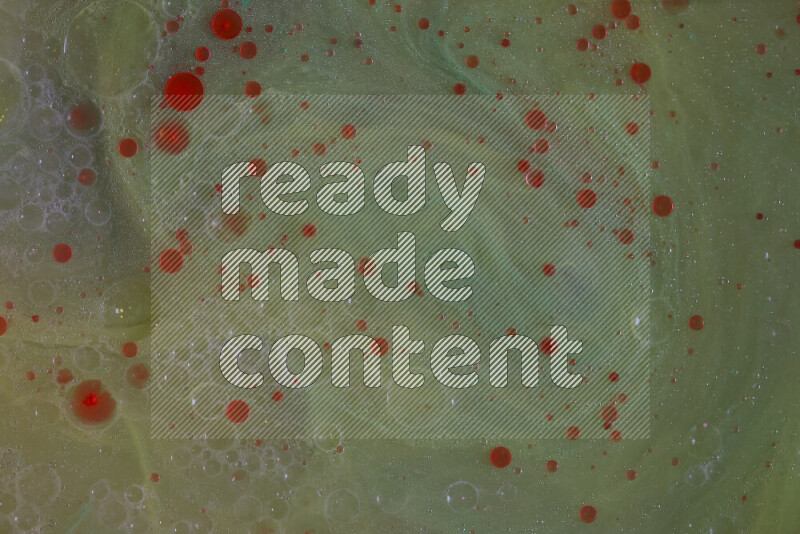 تلتقط الصورة تناثرا للطلاء الأحمر علي خلفية خضراء