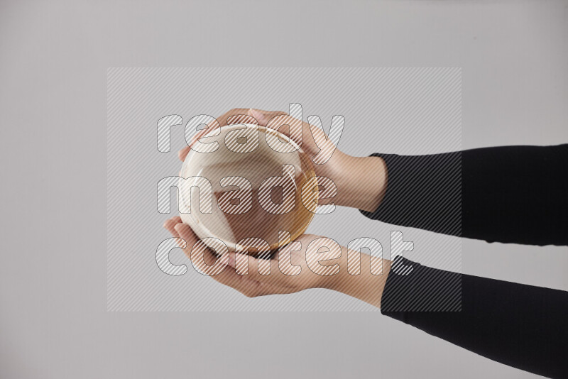 A woman in black abaya holding different pottery essentials in different positions