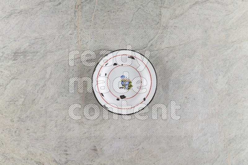 Top View Shot Of A Vintage Metal Plate On Grey Marble Flooring