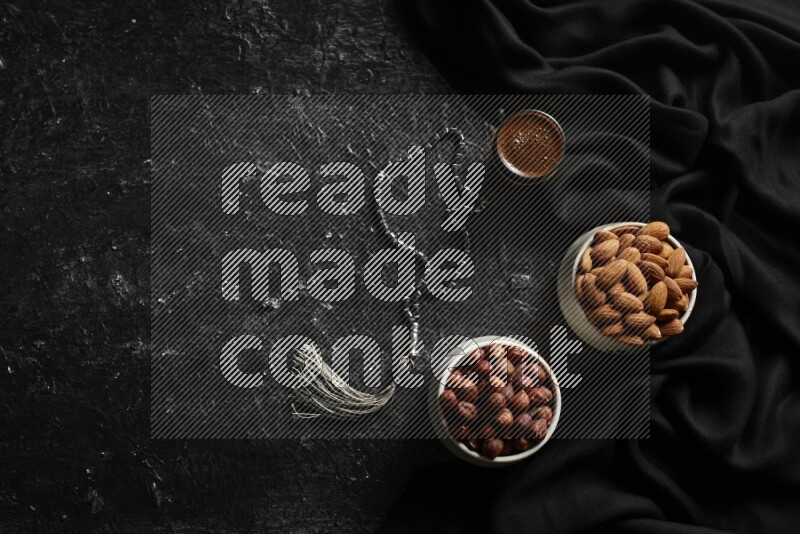 مكسرات في أطباق فخارية مع القهوة علي خلفية سوداء خشبية