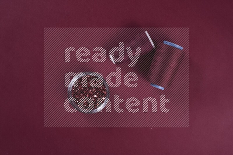 A red collection of sewing and tailoring tools arranged on a red background