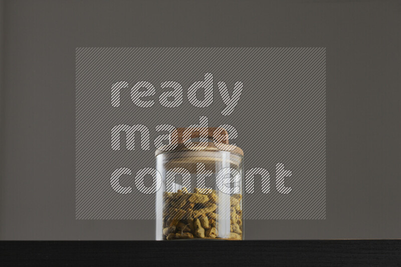 Turmeric in a glass jar on black background