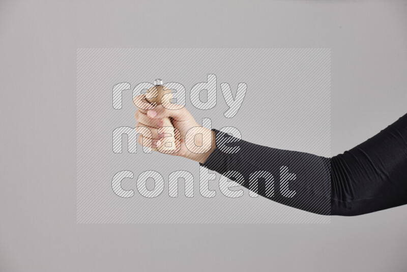 A woman in black abaya holding different wooden essentials in different positions