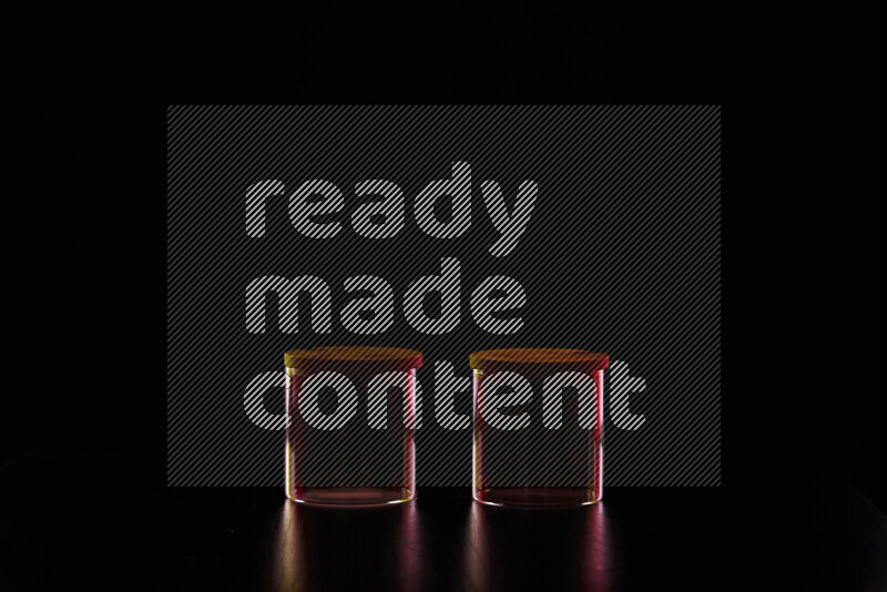 Glassware with rim light in red and yellow against black background