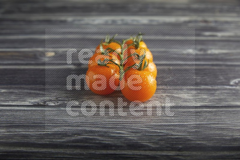 orange cherry tomato vein on a textured grey wooden background 45 degree