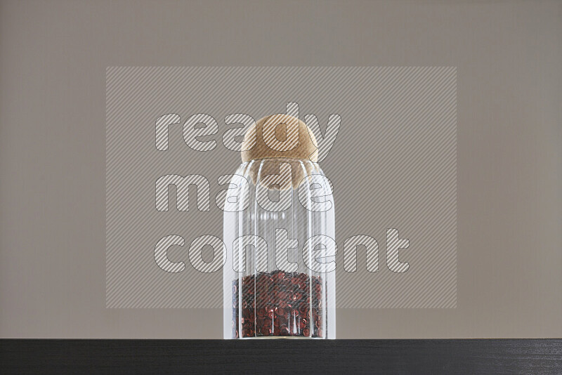 Sequins in a glass jar on black background