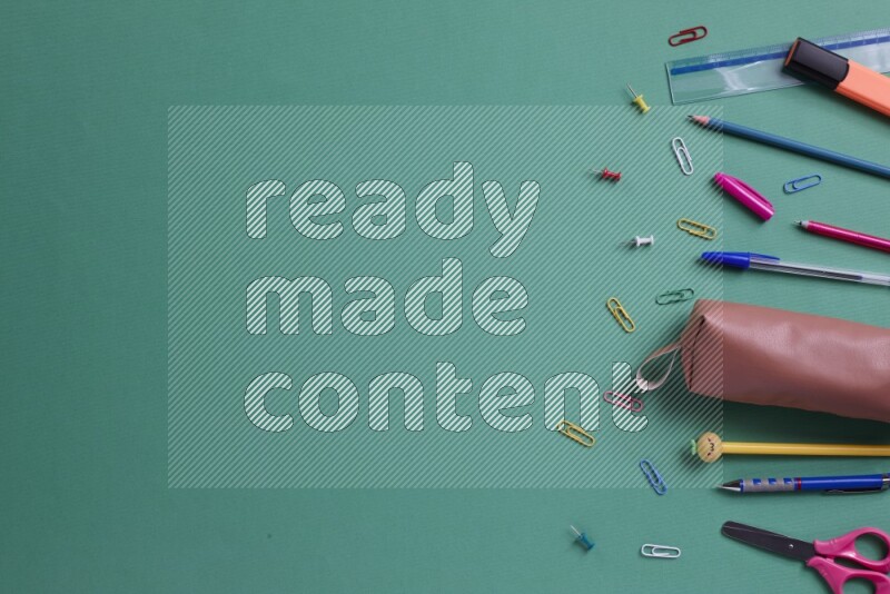 مستلزمات مدرسية مختلفة على خلفية خضراء