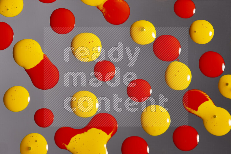 Close-ups of abstract red and yellow paint droplets on the surface