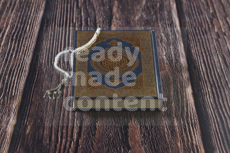 Quran with a prayer beads on wooden background