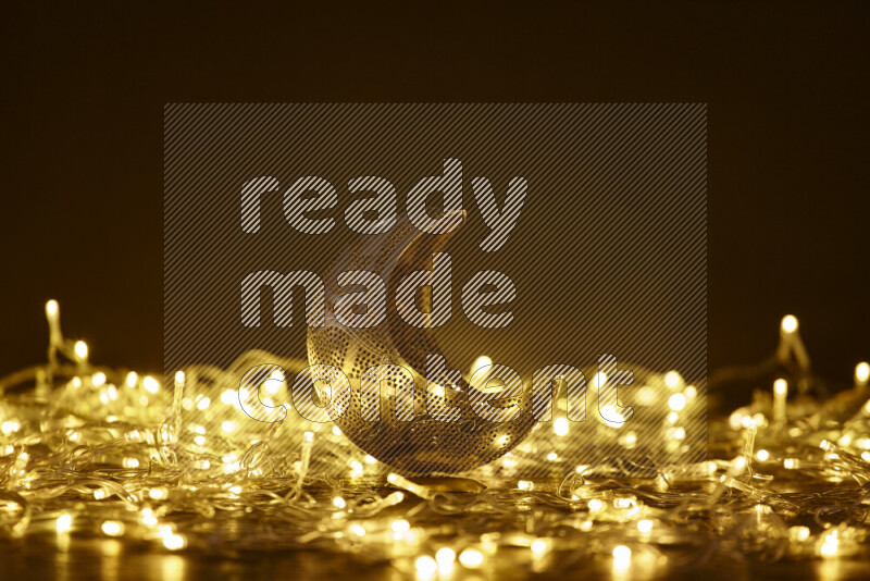 A traditional ramadan lantern surrounded by glowing fairy lights in a dark setup