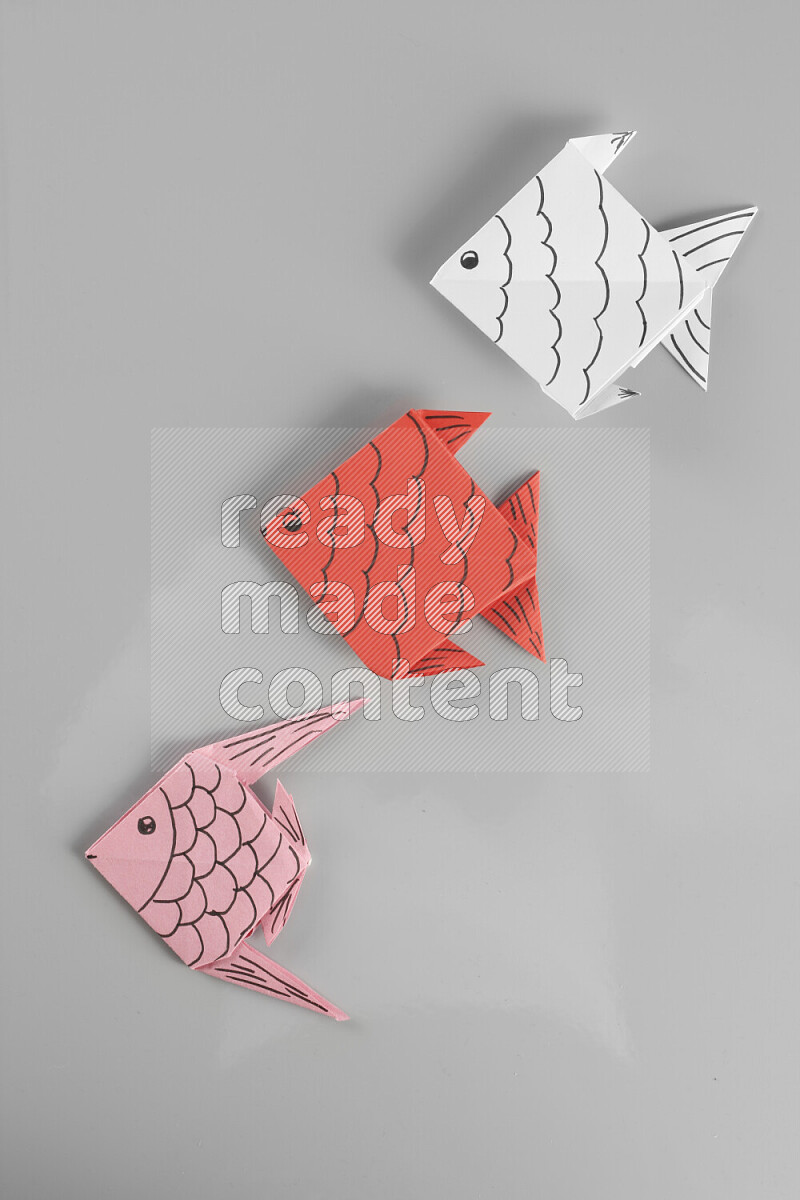 Origami fish on grey background