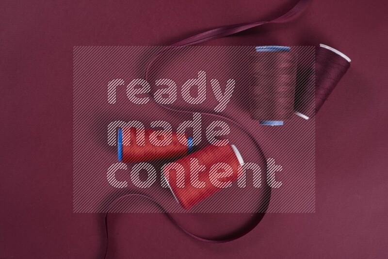 A red collection of sewing and tailoring tools arranged on a red background