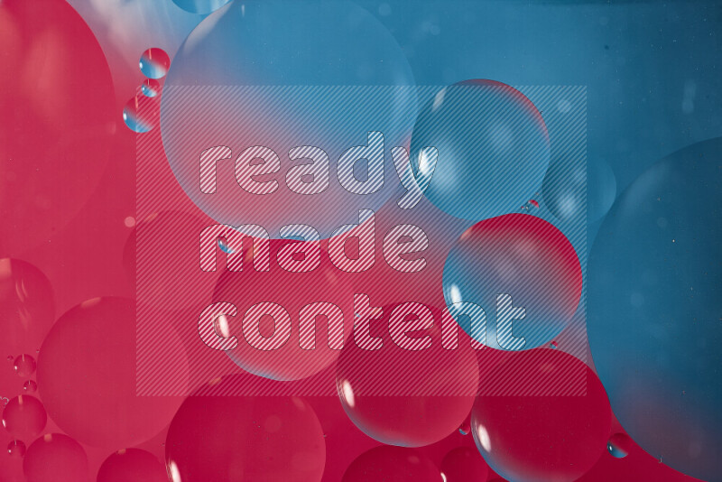 لقطات مقربة لفقاعات من الزيت على سطح الماء باللون الأزرق والوردي