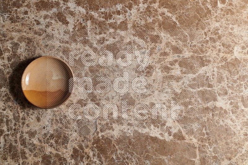 Top View Shot Of A Multicolored Pottery plate On beige Marble Flooring