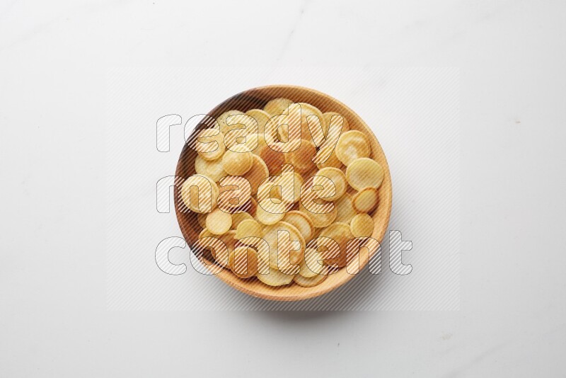 Top-view shot of plain cereal pancakes in a round bowl on white background