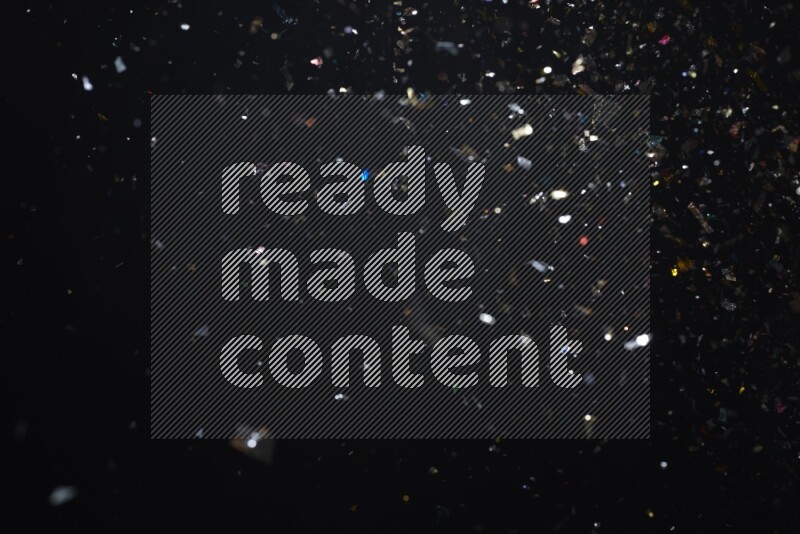 Falling multicolored confetti on black background