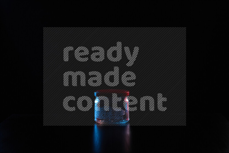 Glassware with rim light in red and blue against black background