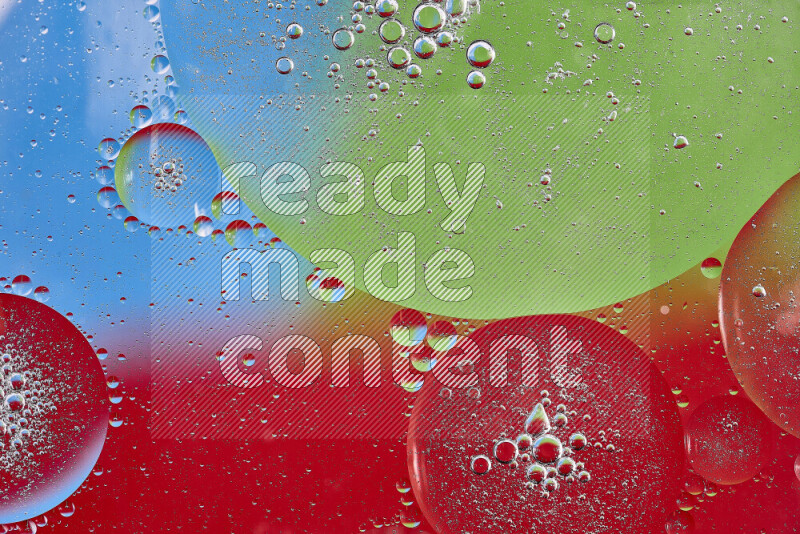 Close-ups of abstract oil bubbles on water surface in shades of red, green and blue